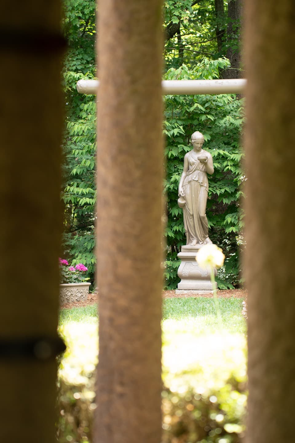 Classical garden statue seen through an architectural opening